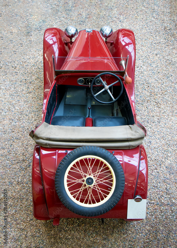 Fototapeta premium The above view of vintage car with spare wheel. The red classic car with classical wheel on rear.