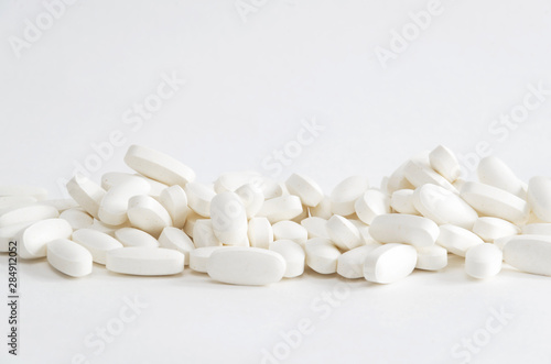 Group of white magnesium pills on white backgrond