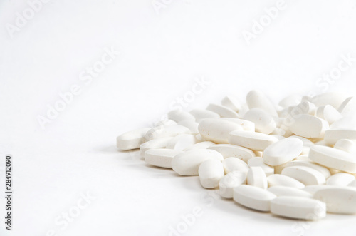 White pills on white backgrond close up