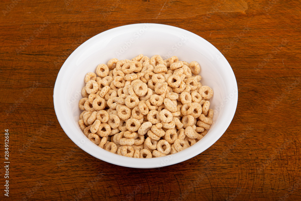 A breakfast of toasted oat ceral on a wood table. A breakfast of toasted oat ceral on a wood table.