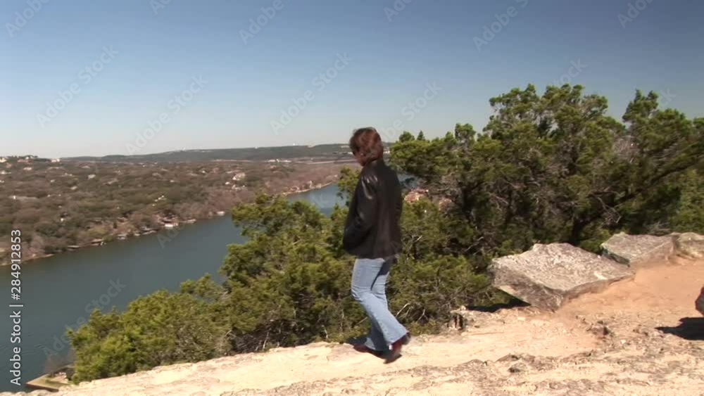a woman taking in the landscape from the top of a mountain a woman taking in the landscape from the top of a mountain