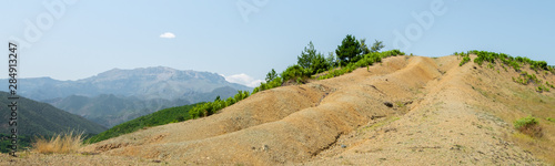 Albanian nature landscape. Sandy hills with rainwater sign on the ground.