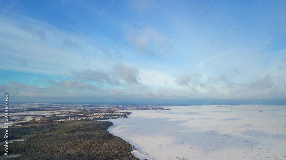 Fototapeta premium Aerial view of white winter frozen lake from above. bird's eye, drone shot. amazing natural background