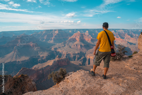 A boy with a yellow shirt at Sunset at the Mojave Point in Grand Canyon. Arizona