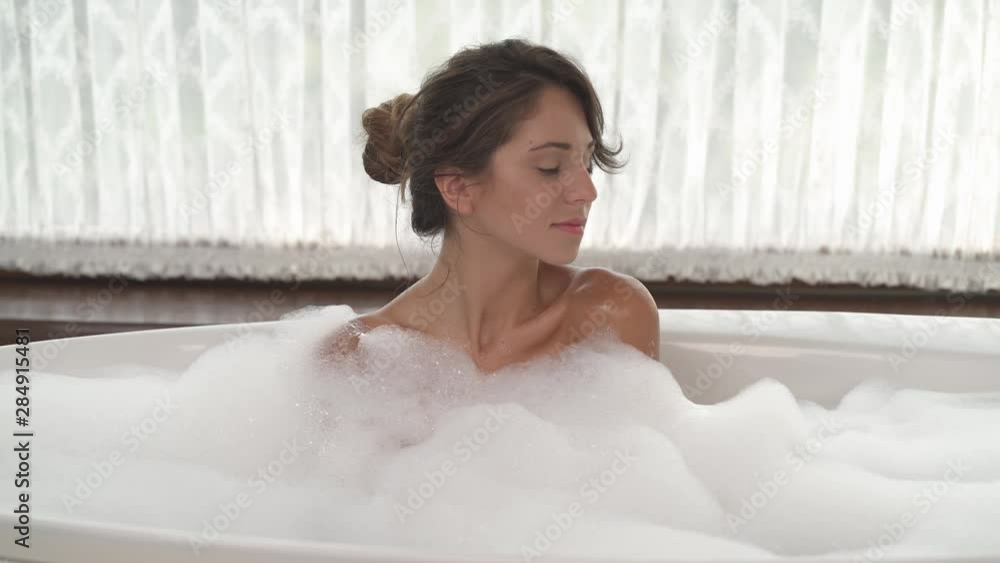 A close-up of an attractive woman enjoying warm bubble bath. Romantic concept A close-up of an attractive woman enjoying warm bubble bath. Romantic concept