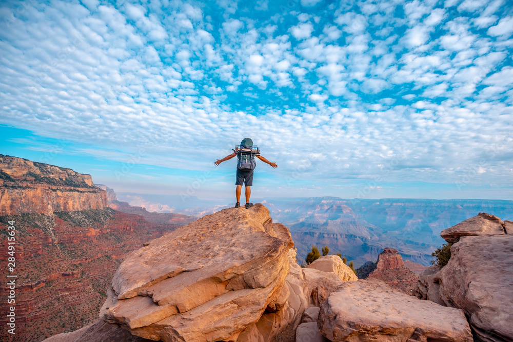 A young man with open arms on a viewpoint of the descent of the South Kaibab Trailhead. Grand Canyon, Arizona