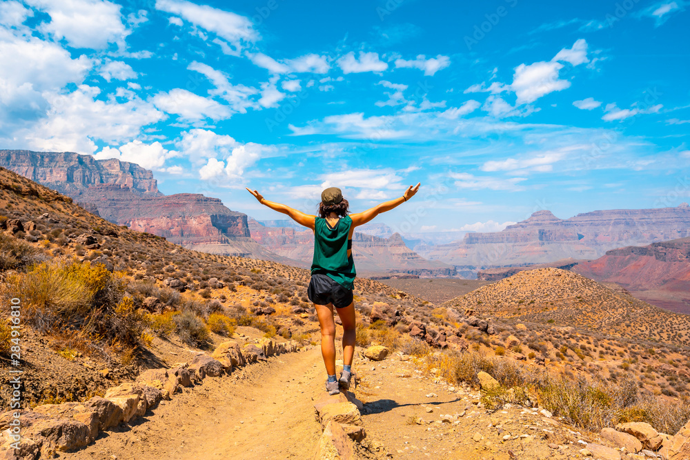 A young woman with open arms on the South Kaibab Trailhead trek. Grand Canyon