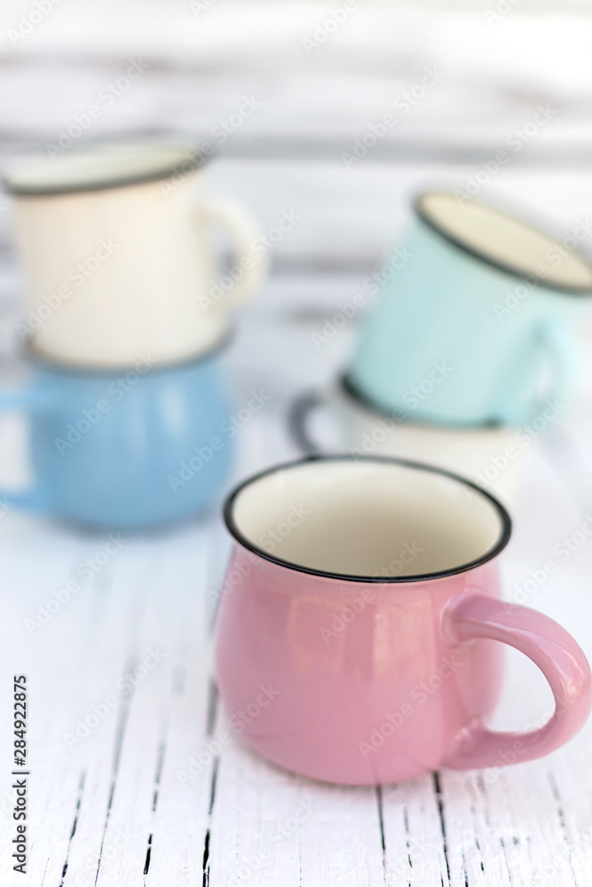 Enameled mugs in retro style on an old wooden background. Enameled mugs in retro style on an old wooden background.