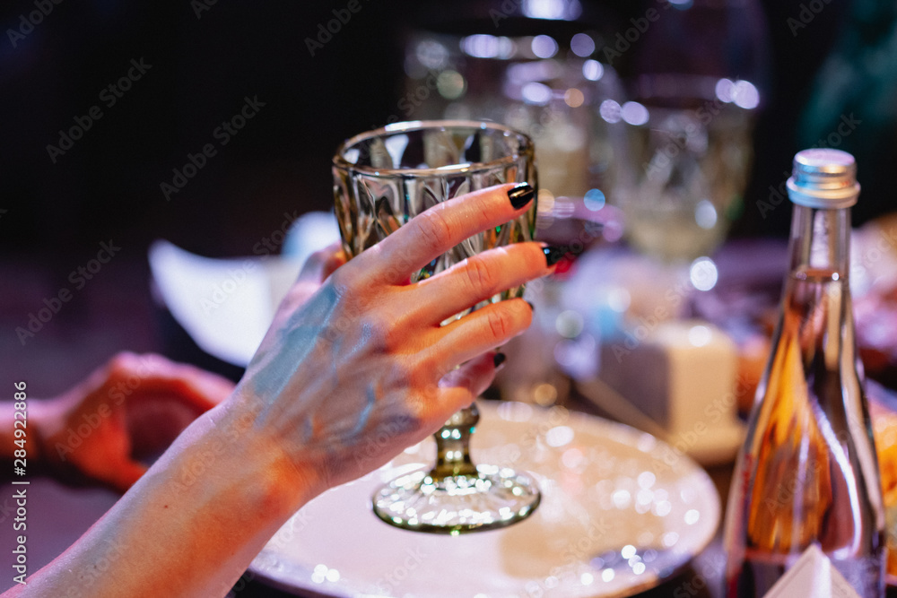 Woman holding a glass of red wine. Dinner at the restaurant, party