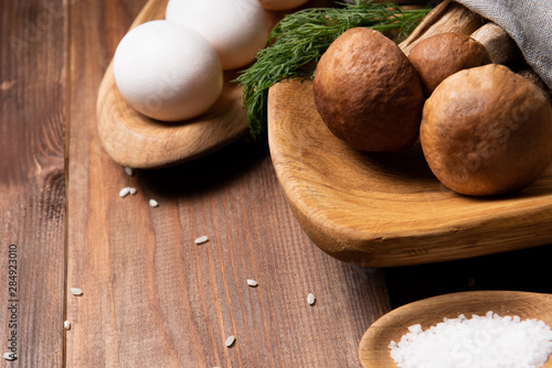 wooden tray with porcini mushrooms on a wooden table. Ingredients before cooking. Copy space