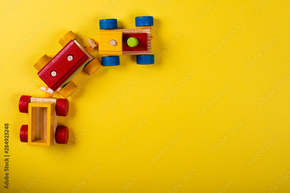 Obraz premium Wooden train on yellow background with space for text.