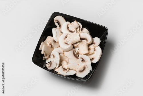 resh cutted mushrooms in black plate. champignon mushrooms photo