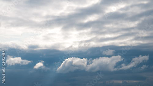 Fototapeta Naklejka Na Ścianę i Meble -  gloomy clouds with a gleam of the sun passing into the clear sky