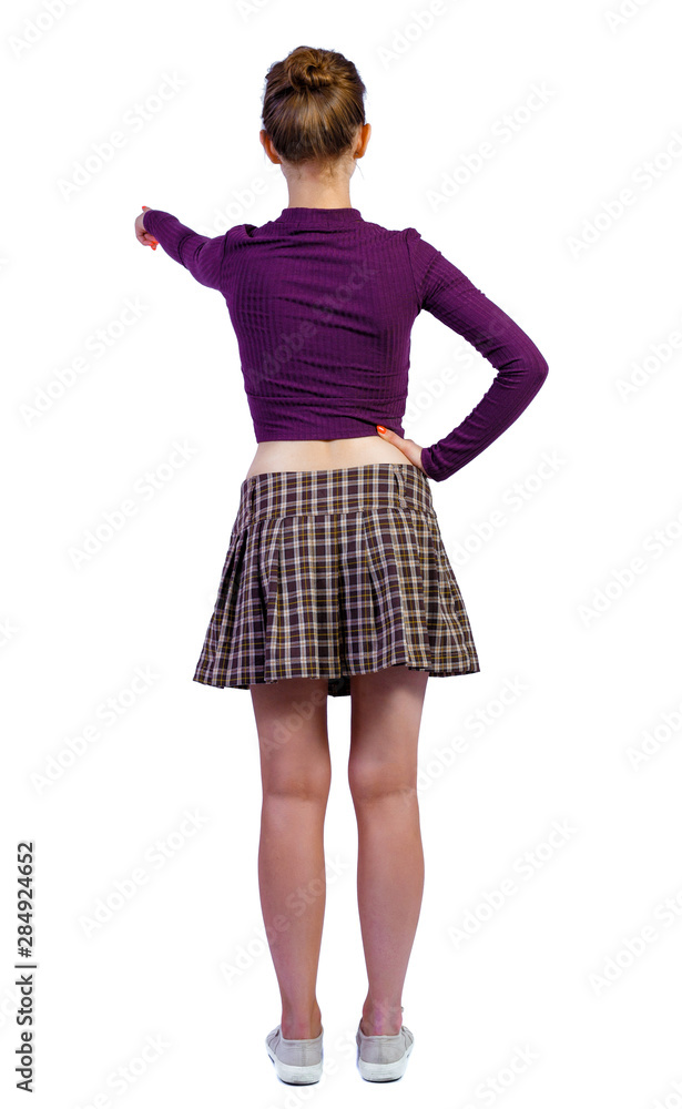 Fototapeta premium Back view of a woman points his hand upwards.