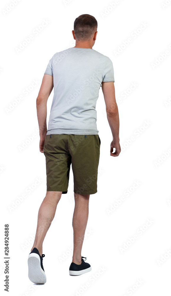 Back view of going handsome man in shorts. Back view of going handsome man in shorts.