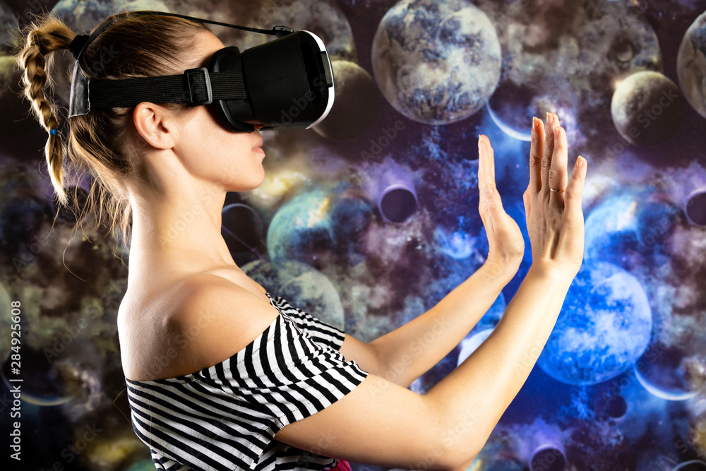 Naklejka premium A woman is looking through virtual reality at space. Space background