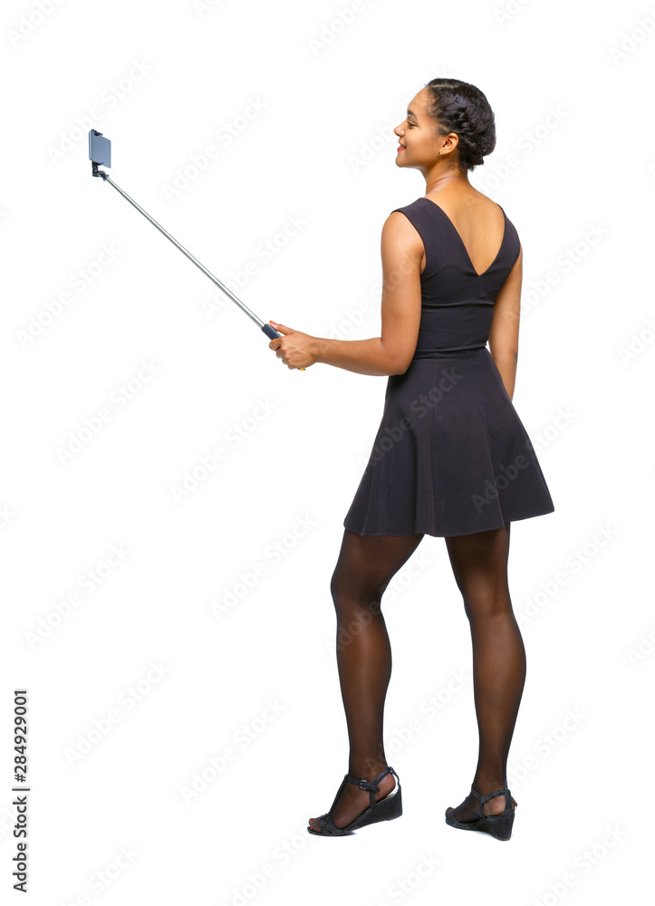 Back view of an African-American woman taking a selfie. Back view of an African-American woman taking a selfie.