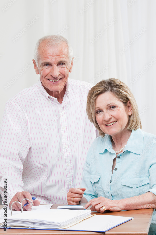 Senior couple doing paperwork, smiling, portrait Senior couple doing paperwork, smiling, portrait