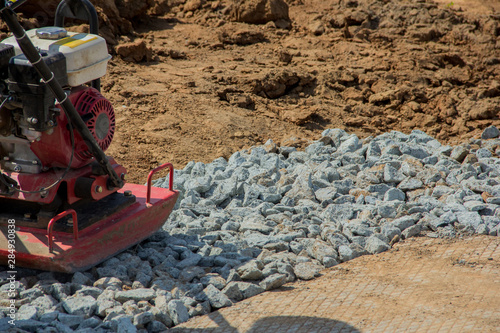 Rammer at work. Rammer rubble on the edge of the road. Construction work on the road