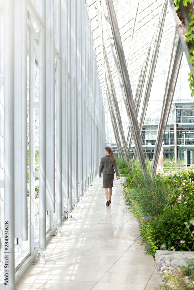 Businesswoman walking in modern courtyard Businesswoman walking in modern courtyard