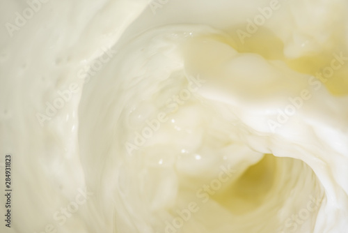 Bright background with pouring milk is macro