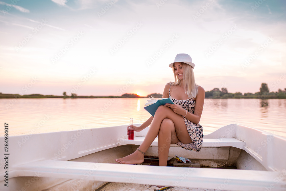 Girl reading a book while sitting on the boat