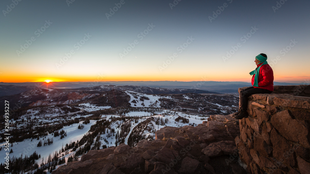 A woman sitting on a wall at forest service lookout at the summit of Brian Head, Utah. A woman sitting on a wall at forest service lookout at the summit of Brian Head, Utah.