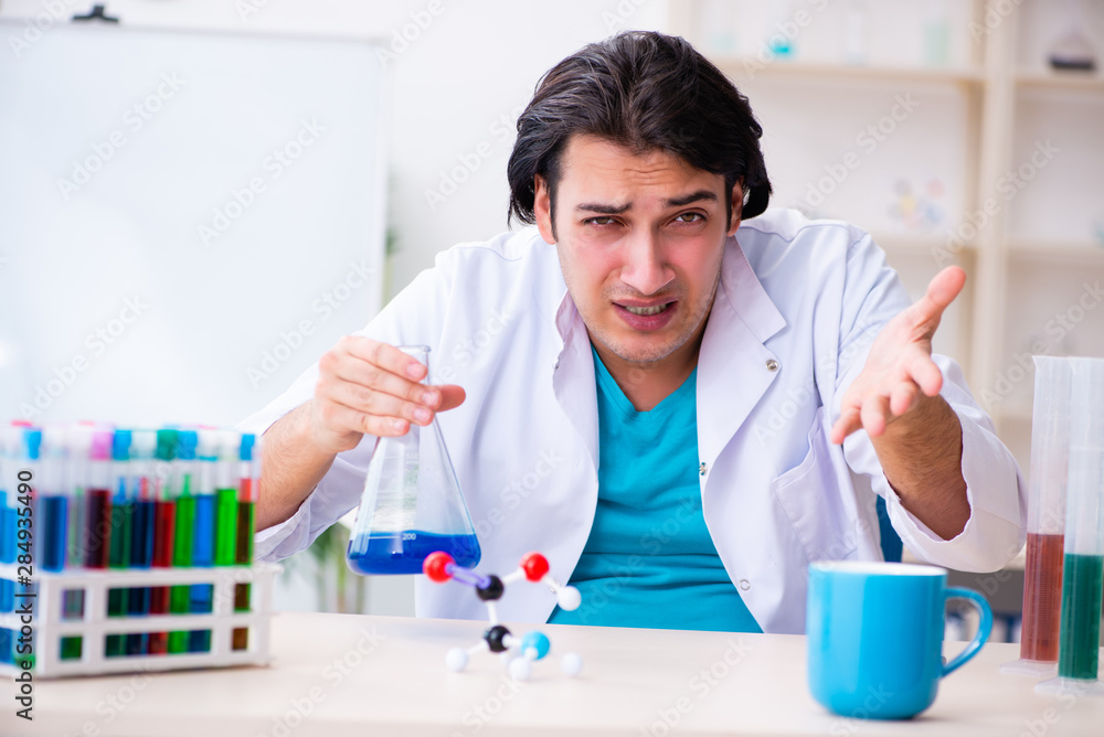 Young male chemist working in the lab Young male chemist working in the lab