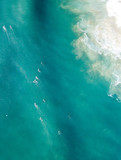 Surfers in the  water shot from a drone