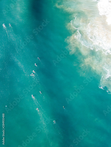 Surfers in the water shot from a drone