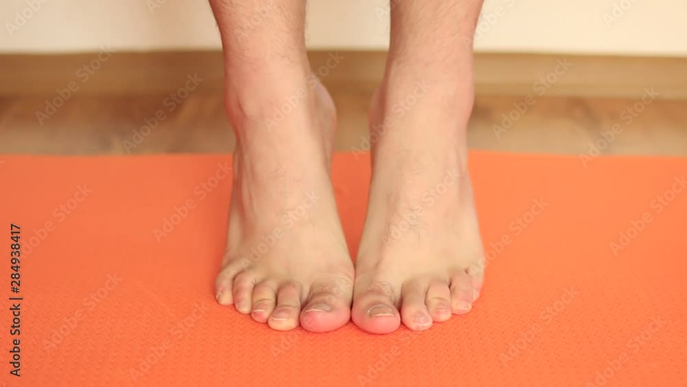 young man doing exercises for his feet and toes young man doing exercises for his feet and toes