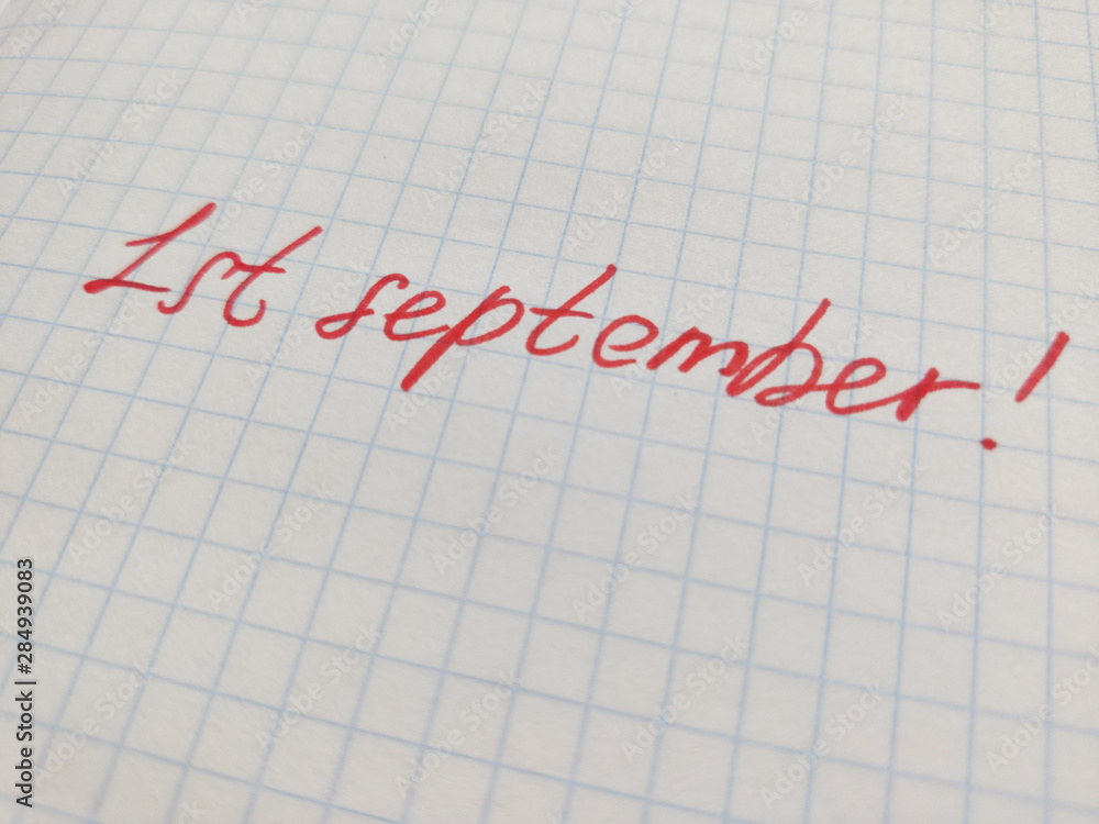 Handwritten inscription in felt-tip pen on the first of september on squared paper. Preparation for school, the beginning of the school year, September 1, a sheet in a cage Handwritten inscription in felt-tip pen on the first of september on squared paper. Preparation for school, the beginning of the school year, September 1, a sheet in a cage