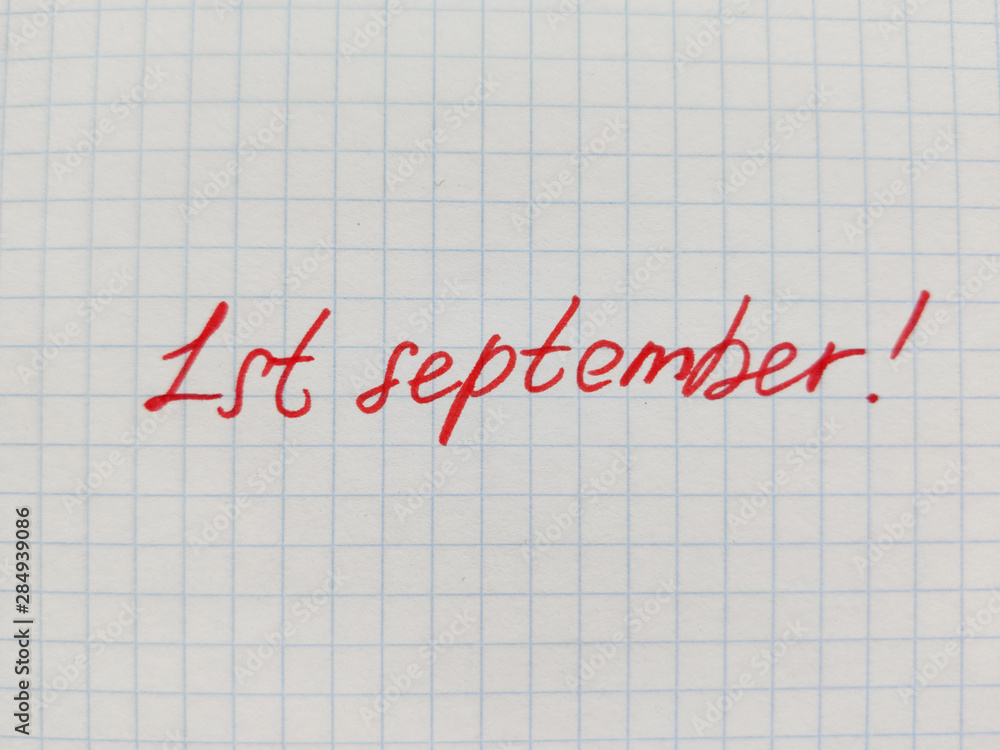 Handwritten inscription in felt-tip pen on the first of september on squared paper. Preparation for school, the beginning of the school year, September 1, a sheet in a cage Handwritten inscription in felt-tip pen on the first of september on squared paper. Preparation for school, the beginning of the school year, September 1, a sheet in a cage