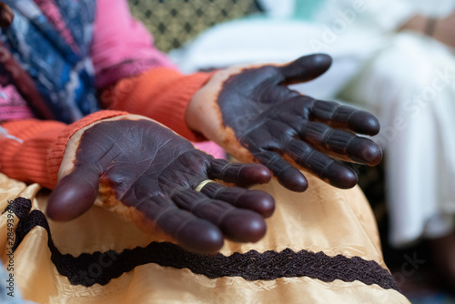 Close up of elderly woman painted hands with henna in celebration.