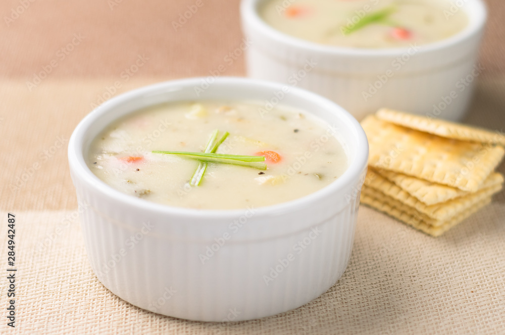 Clam chowder from above. Traditionally from the United States, New England Clam Chowder is a delicious type of hearty and creamy soup. It commonly made with clams, potatoes, onions and celery. Clam chowder from above. Traditionally from the United States, New England Clam Chowder is a delicious type of hearty and creamy soup. It commonly made with clams, potatoes, onions and celery.