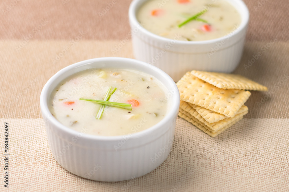 Warm bowls of clam chowder. Traditionally from the United States, New England Clam Chowder is a delicious type of hearty and creamy soup. It commonly made with clams, potatoes, onions and celery. Warm bowls of clam chowder. Traditionally from the United States, New England Clam Chowder is a delicious type of hearty and creamy soup. It commonly made with clams, potatoes, onions and celery.