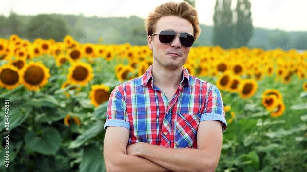 Cool and stylish young male farmer with sunglasses successfully stands