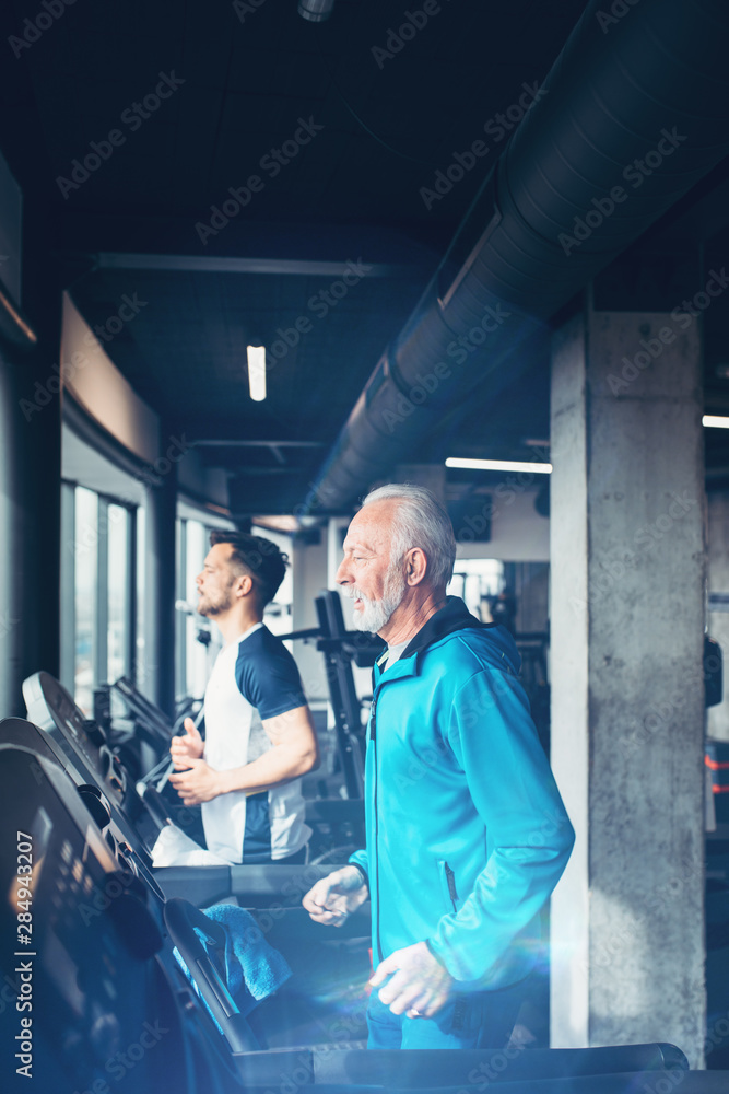 Senior and young sportsmen exercising at gym. Senior and young sportsmen exercising at gym.