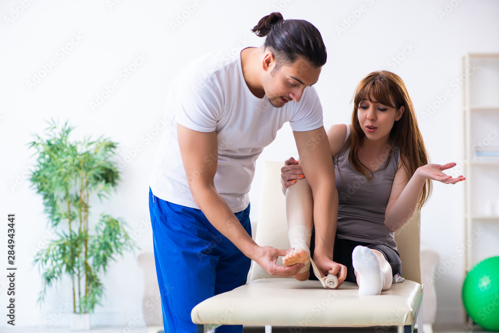 Obraz premium Leg injured woman visiting young doctor traumatologist