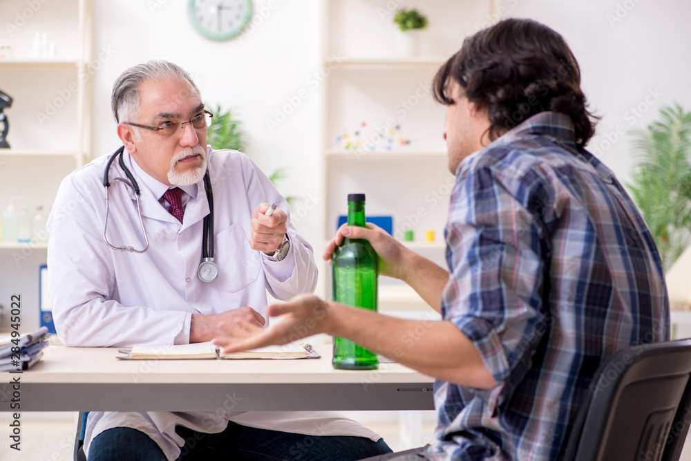 Young male alcoholic visiting old doctor Young male alcoholic visiting old doctor
