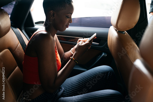 man using her phone in a car