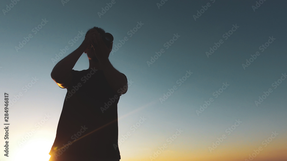 Man photographer silhouette at sunset