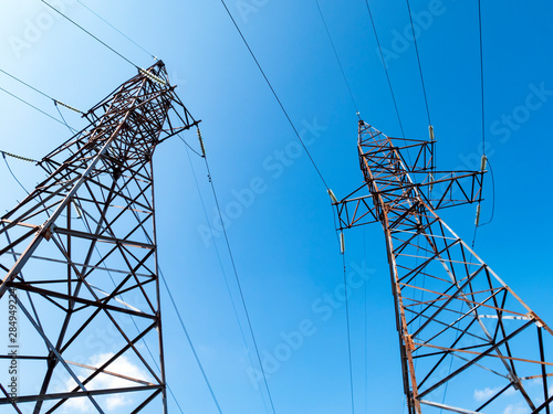 Two power towers against the blue sky on sunny day. Low cloud. photo