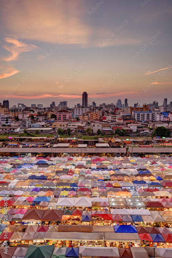 Market with colorful tents in sunset time. This is place in Thailand call Train Market