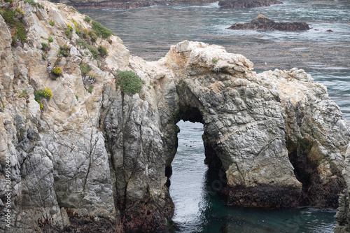Rocks jutting into the Pacific off the Bird Island trail create an archway at Point Lobos Natural Reserve in California.