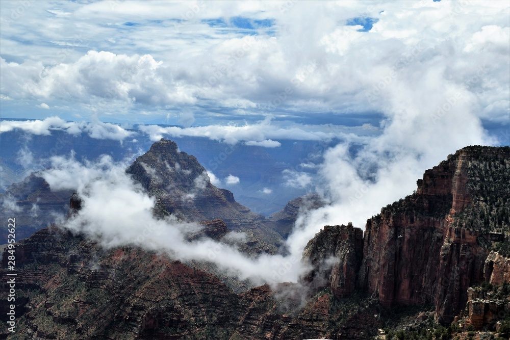 Clouds Amid Blue Skies Hover Among Craggy Formations at North Rim of Grand Canyon