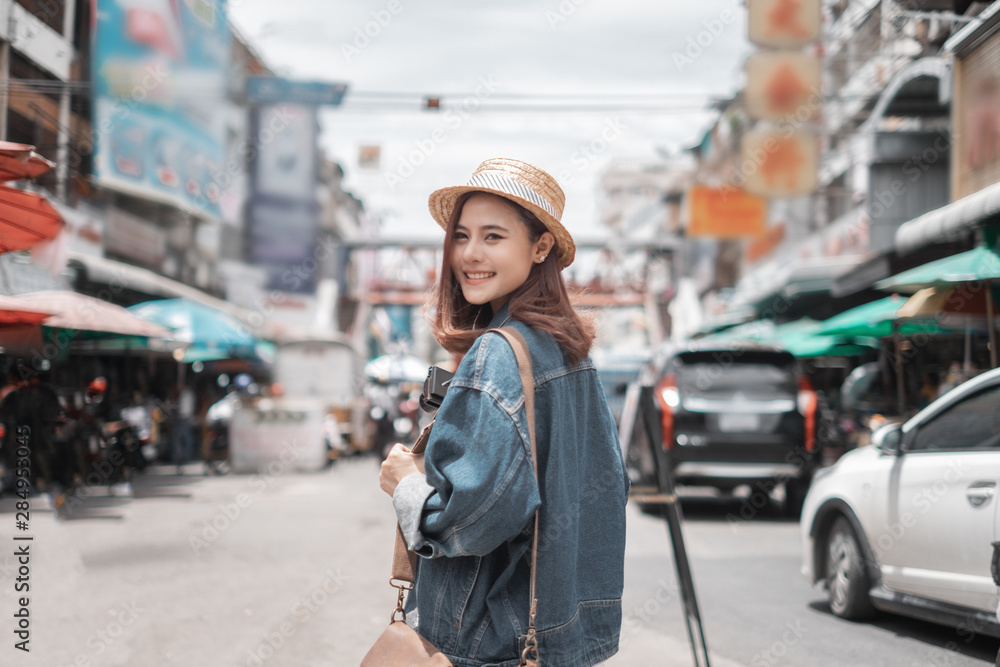 Smiling woman traveler in chiangmai market landmark chiangmai thailand holding smartphone with backpack on holiday, relaxation concept, travel concept Smiling woman traveler in chiangmai market landmark chiangmai thailand holding smartphone with backpack on holiday, relaxation concept, travel concept
