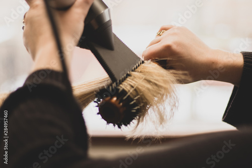 Professional stylist blow-drying hair in a salon