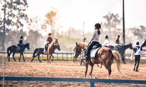 young girl is training to ride a horse horse is in the practice field © photobyphotoboy