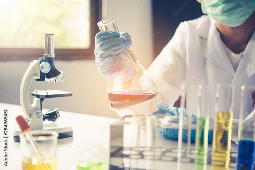 Fototapeta premium Equipment and science experiments oil pouring scientist with test tube yellow making research in laboratory.